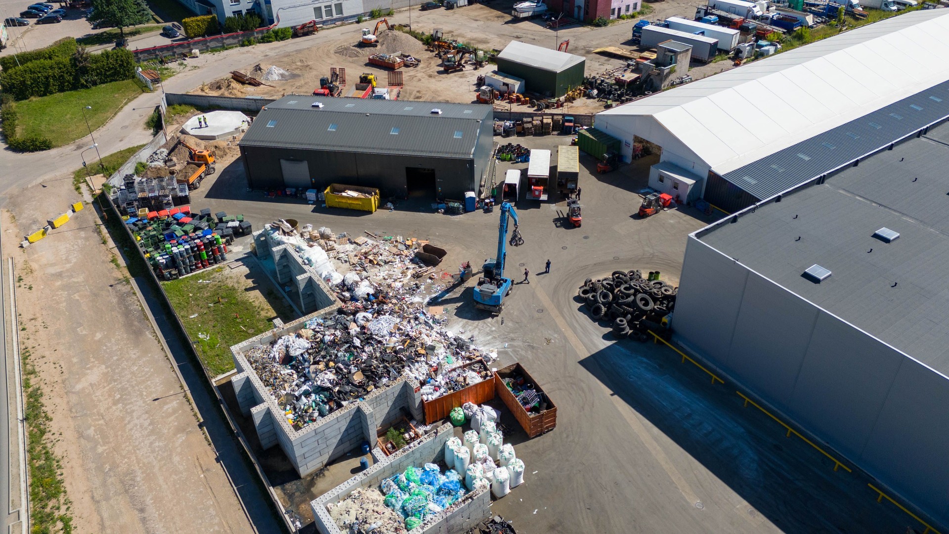 Drone photography of recycling center and machinery sorting material during summer day